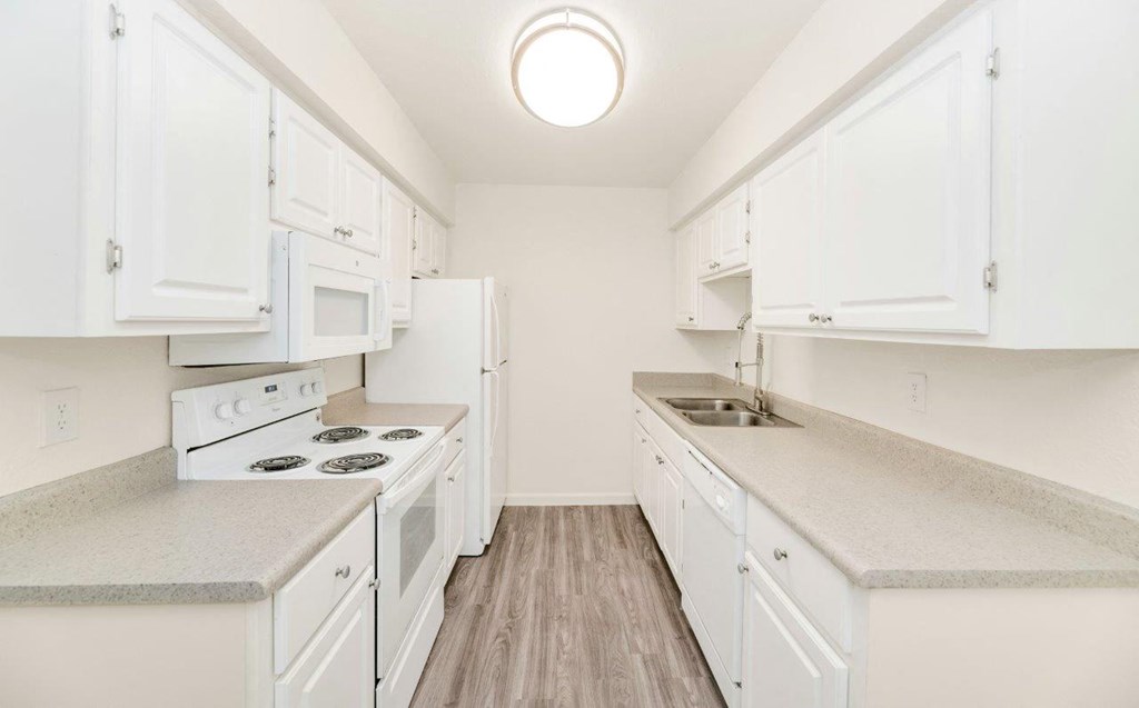 a kitchen with white cabinets and white appliances
