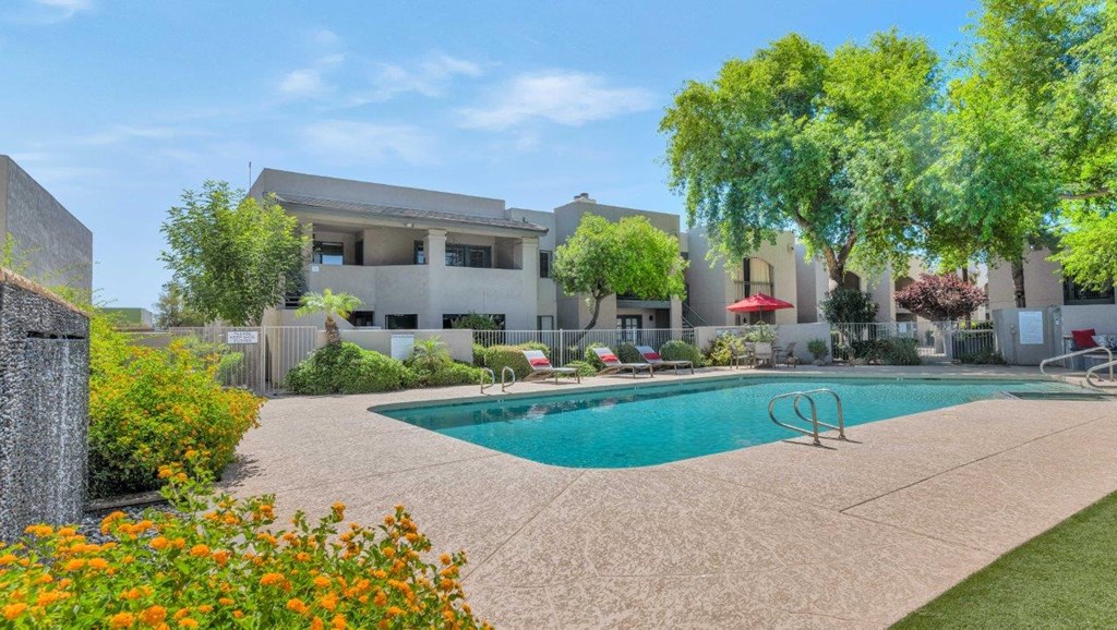 a swimming pool with a white apartment building in the background