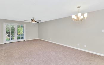 a bedroom with a ceiling fan and a door to a patio