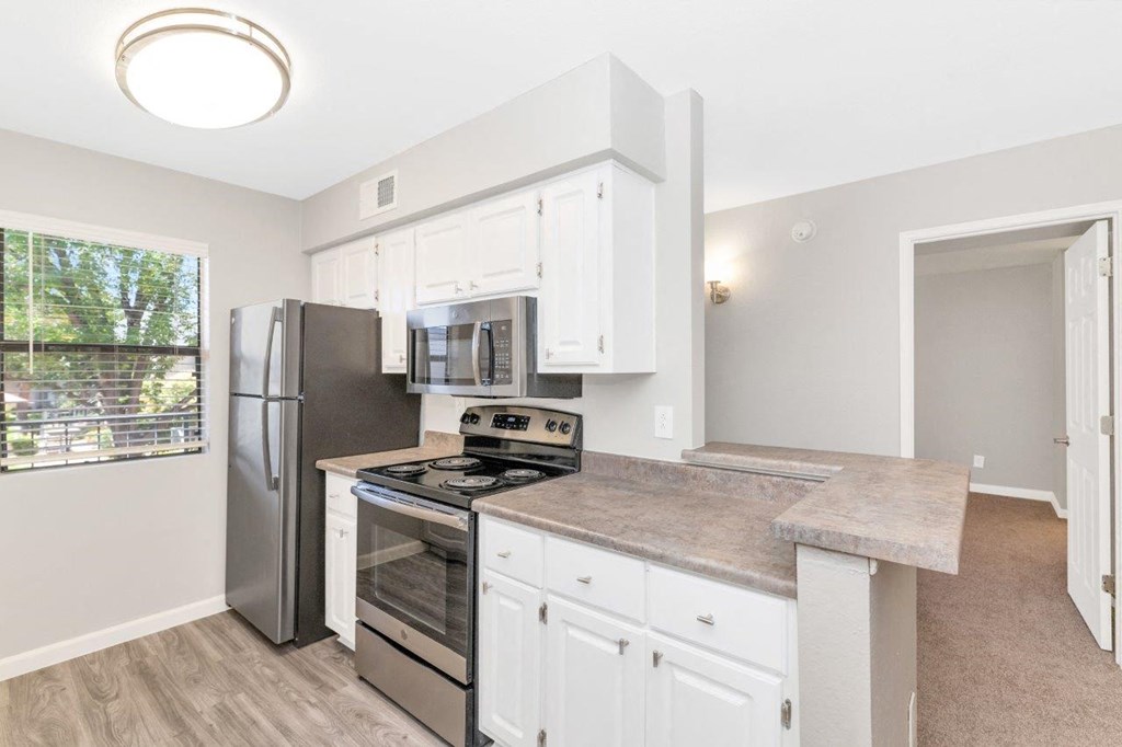 a kitchen with white cabinets and stainless steel appliances