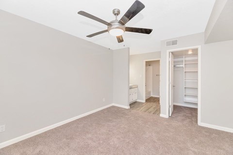 a bedroom with a ceiling fan and a closet