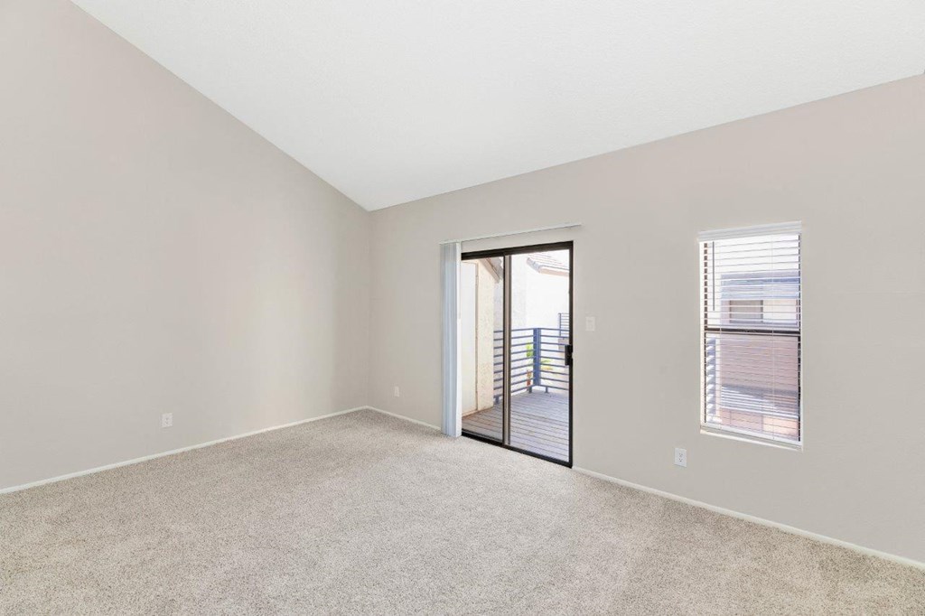 a bedroom with a sliding glass door to a balcony