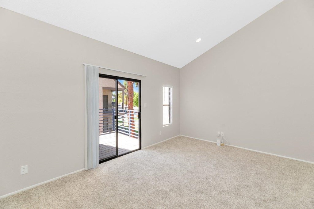 a bedroom with a door to a patio