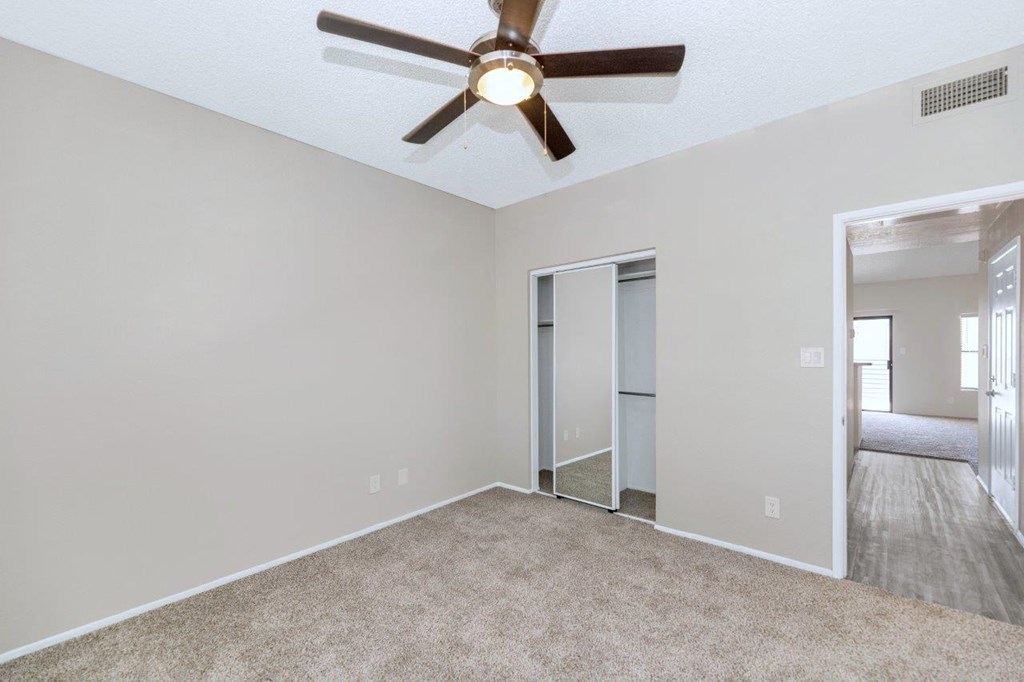 a bedroom with a ceiling fan and a closet
