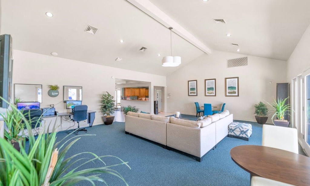 a living room with a couch and chairs in front of a tv