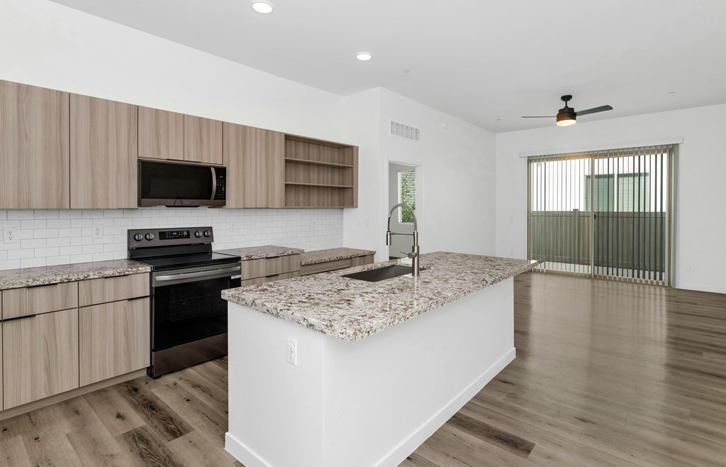A kitchen with a white island and wooden cabinets at Marketside Villas at Verrado, Buckeye, AZ