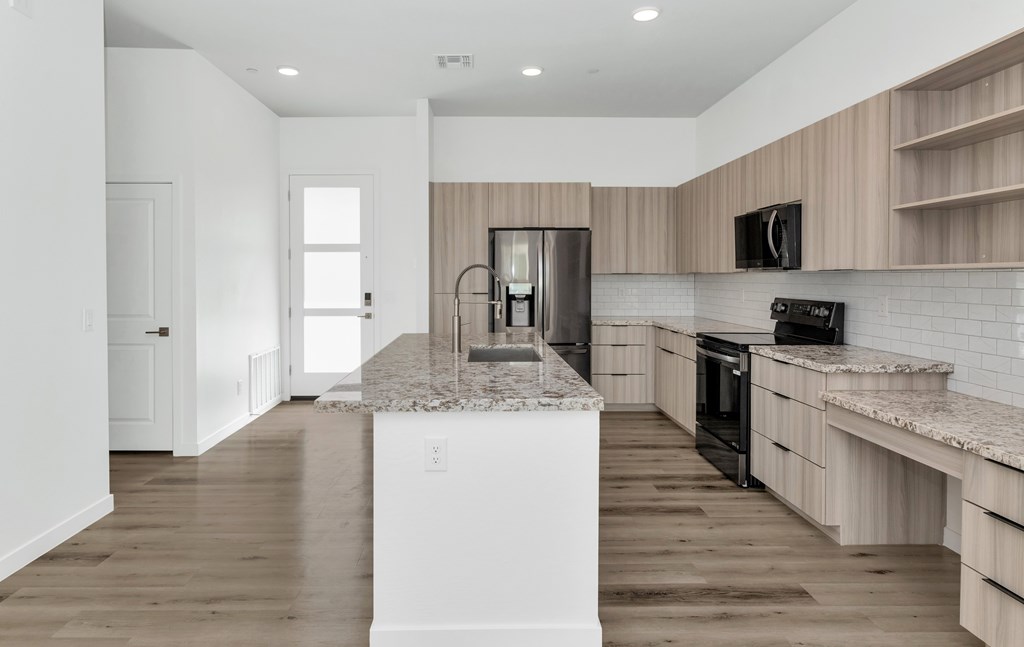 A kitchen with a white island in the middle of the room at Marketside Villas at Verrado, Buckeye, AZ