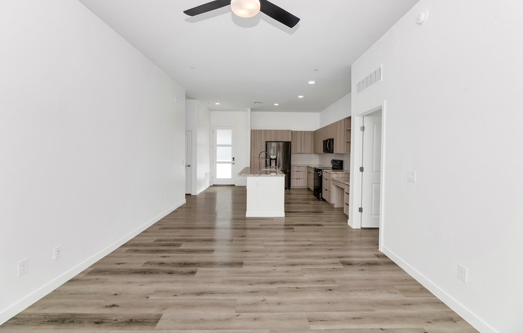 A spacious room with a ceiling fan and wooden flooring at Marketside Villas at Verrado, Buckeye, AZ