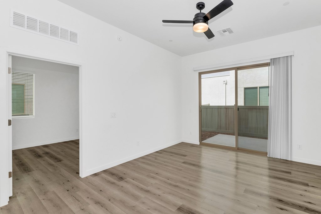A room with a ceiling fan and wooden flooring at Marketside Villas at Verrado, Buckeye, AZ