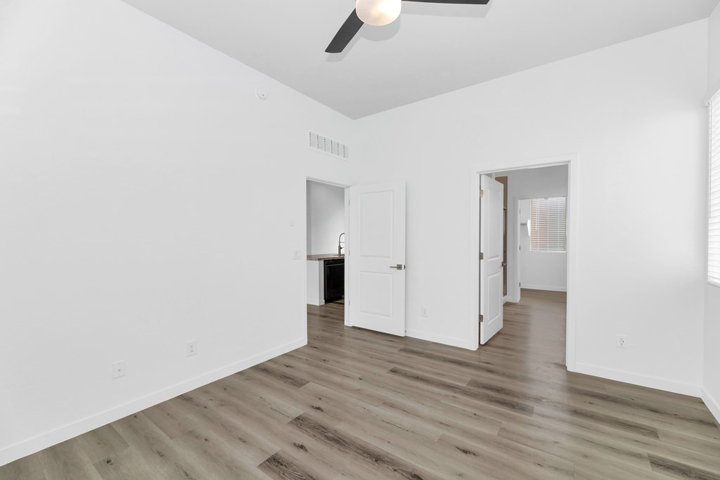 A room with a ceiling fan and wooden flooring at Marketside Villas at Verrado, Buckeye, AZ