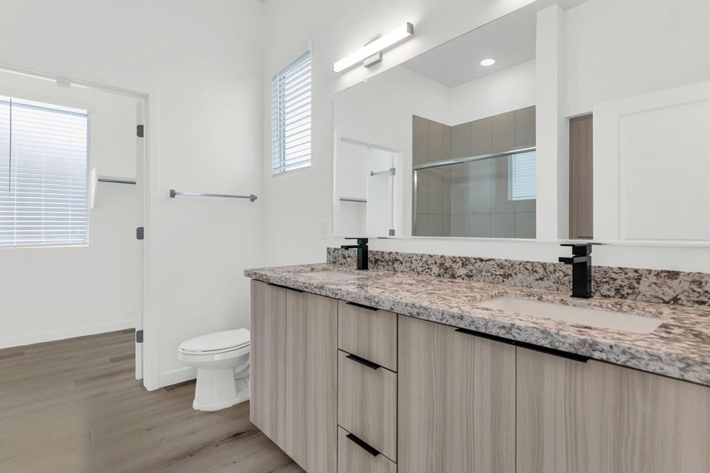 A bathroom with a granite countertop and a toilet at Marketside Villas at Verrado, Buckeye, AZ