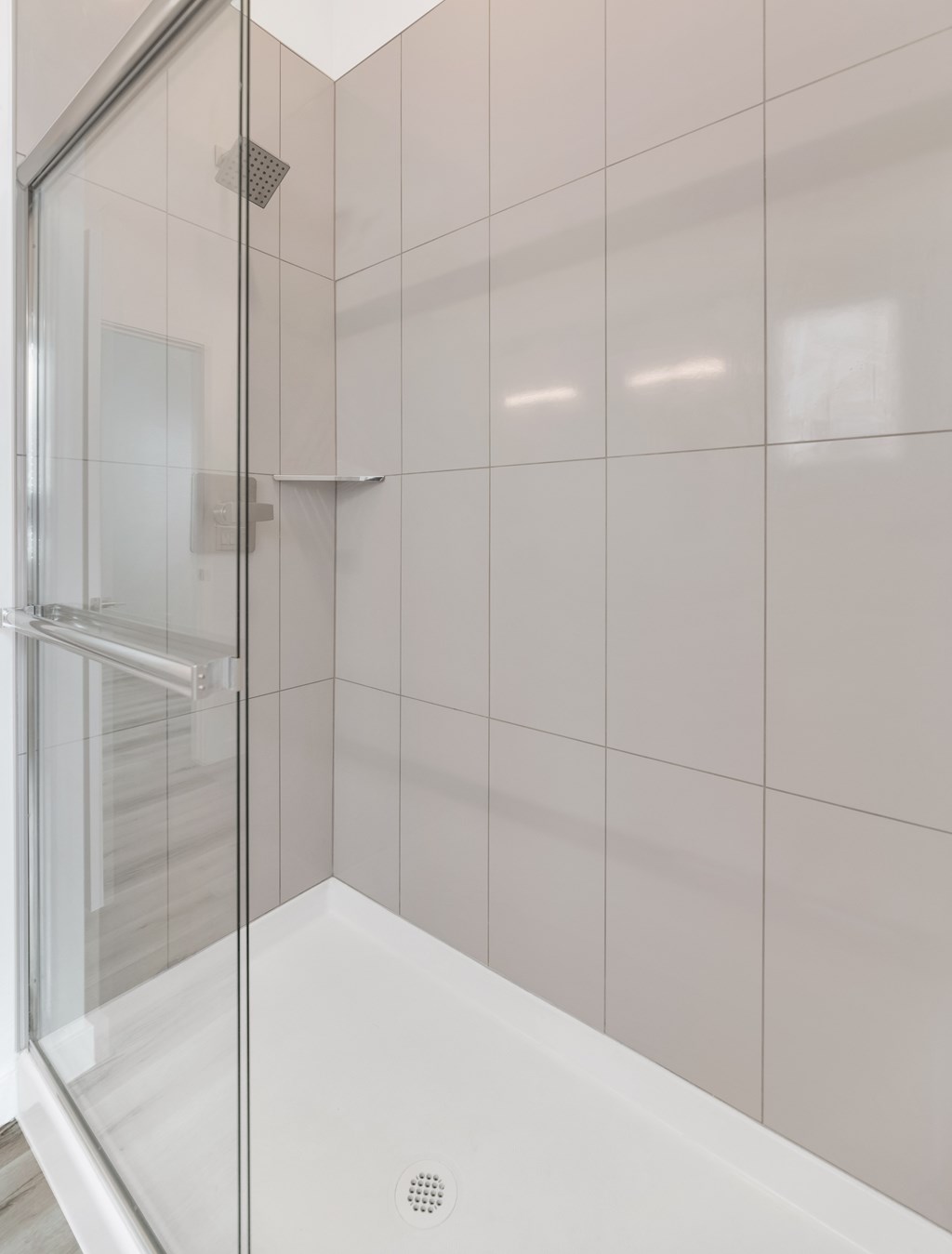 A white bathtub with a shower door in a bathroom at Marketside Villas at Verrado, Buckeye, AZ