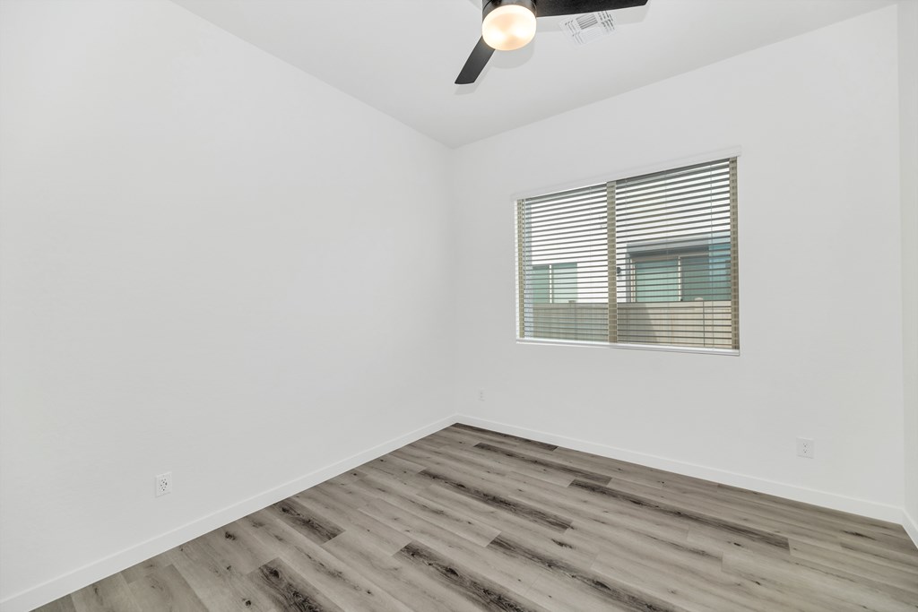 A room with a ceiling fan and a window with blinds at Marketside Villas at Verrado, Buckeye, AZ