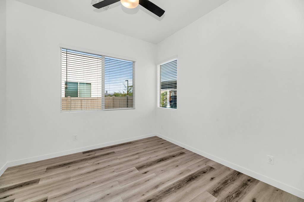 A room with a ceiling fan and two windows at Marketside Villas at Verrado, Buckeye, AZ