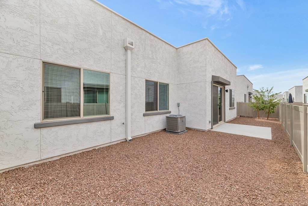A white building with a brown gravel ground at Marketside Villas at Verrado, Buckeye, AZ