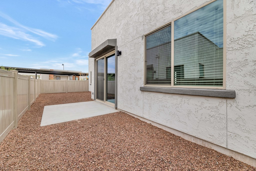 A modern house with a glass door and a gravel driveway at Marketside Villas at Verrado, Buckeye, AZ