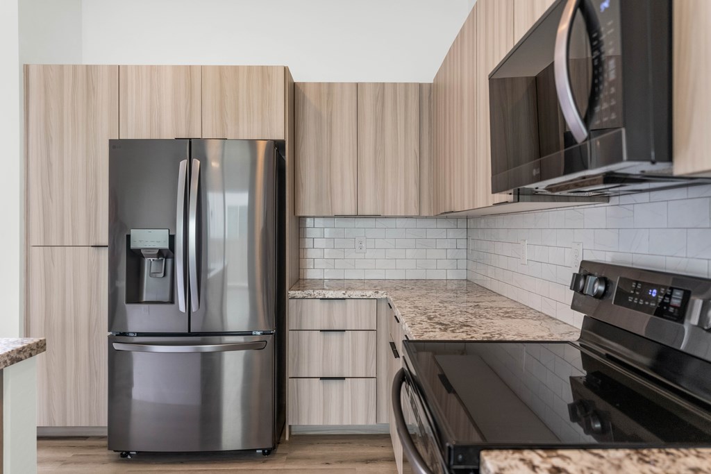 A modern kitchen with a stainless steel refrigerator and microwave at Marketside Villas at Verrado, Buckeye, AZ