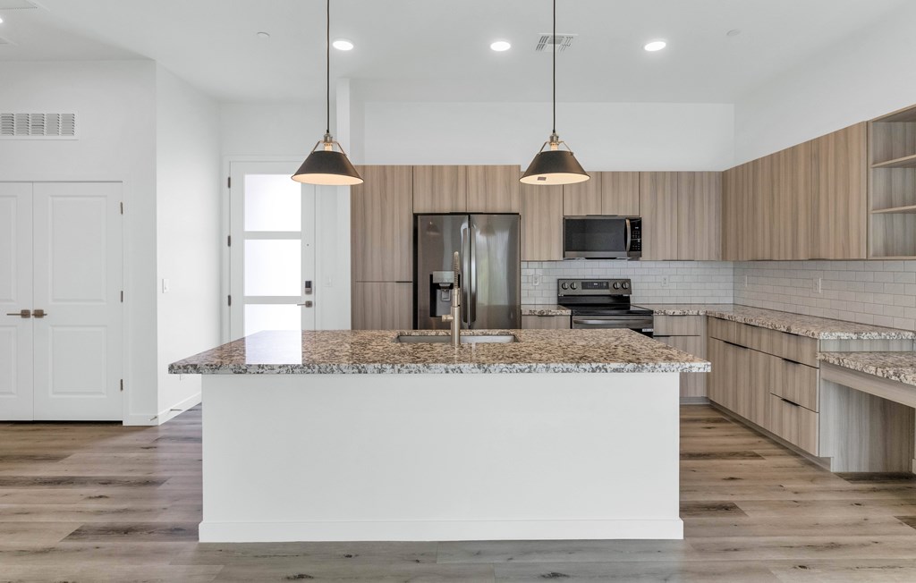 A modern kitchen with a large island in the center at Marketside Villas at Verrado, Buckeye, AZ