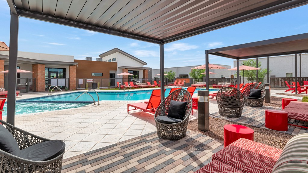 A poolside area with red and black furniture at Marketside Villas at Verrado, Buckeye, AZ
