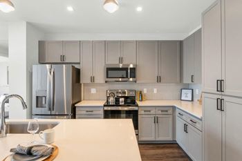 kitchen with gray cabinets and a white counter top at  The Common Apartments, Phoenix, Arizona, 85018