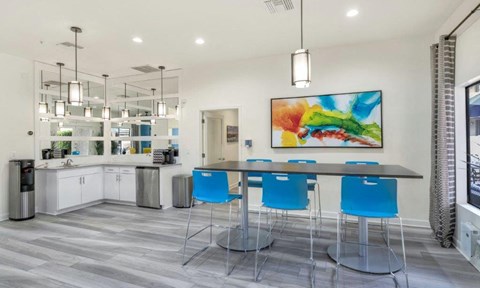 a kitchen with a bar and blue chairs