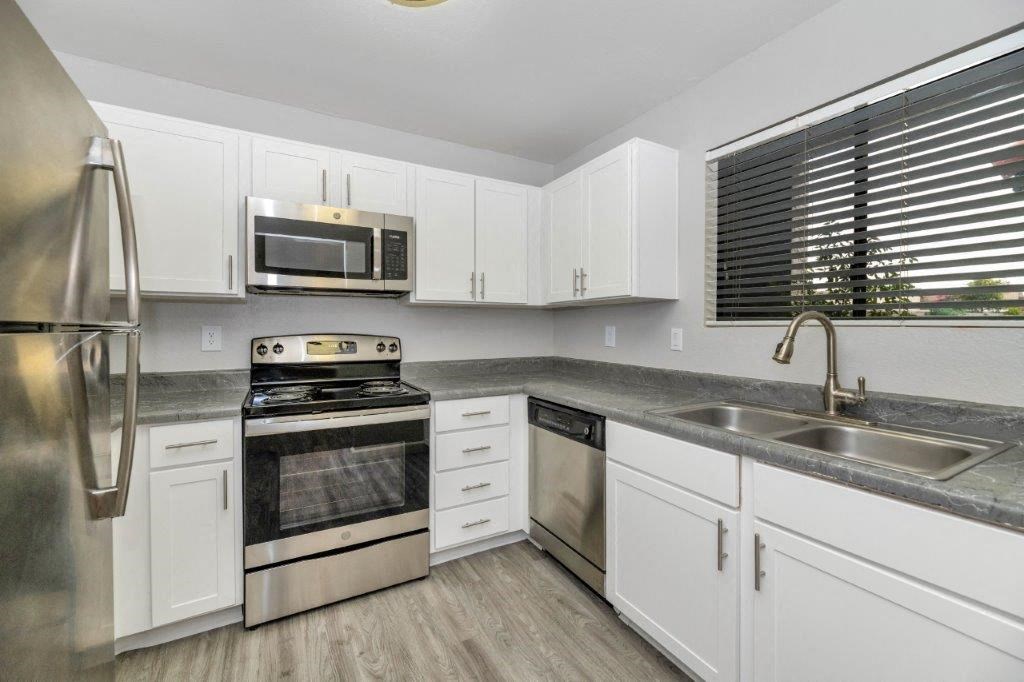 a kitchen with stainless steel appliances and white cabinets