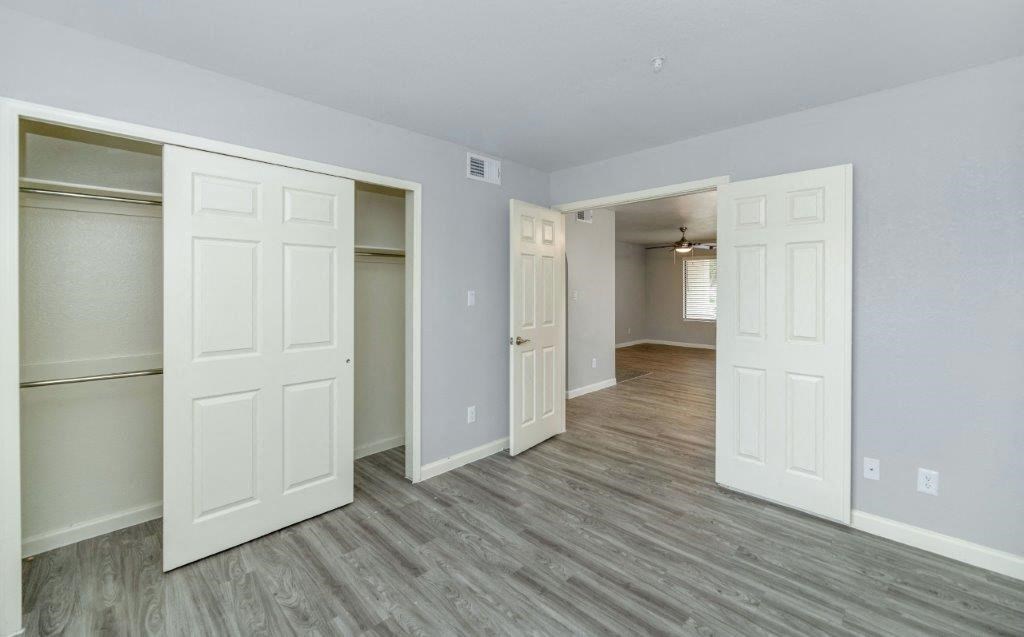the living room and dining room of an empty house with white doors