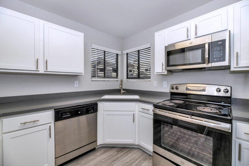 a kitchen with stainless steel appliances and white cabinets