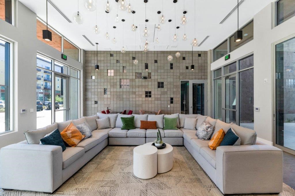 a living room with a large couch and a tile wall