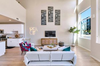 a living room with a white couch and a television