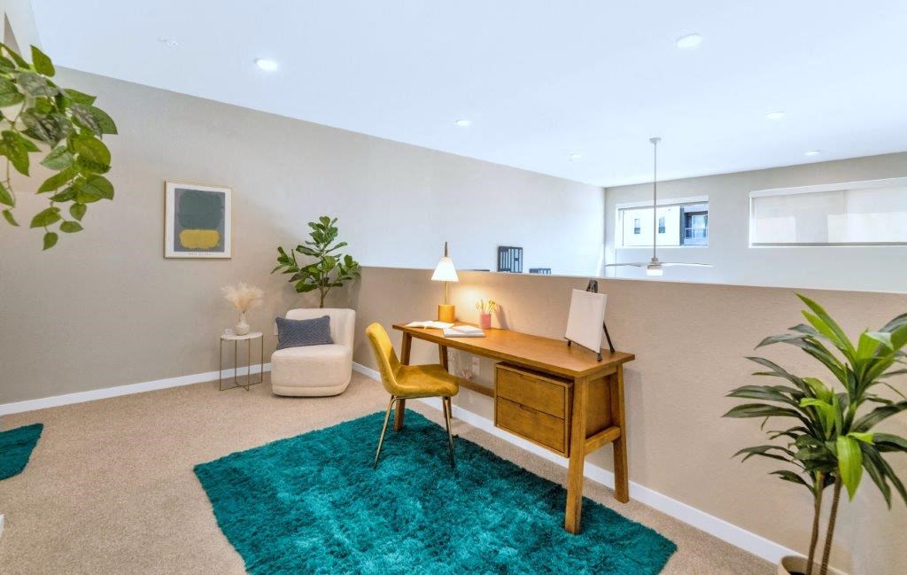 a home office with a wooden desk and a green rug