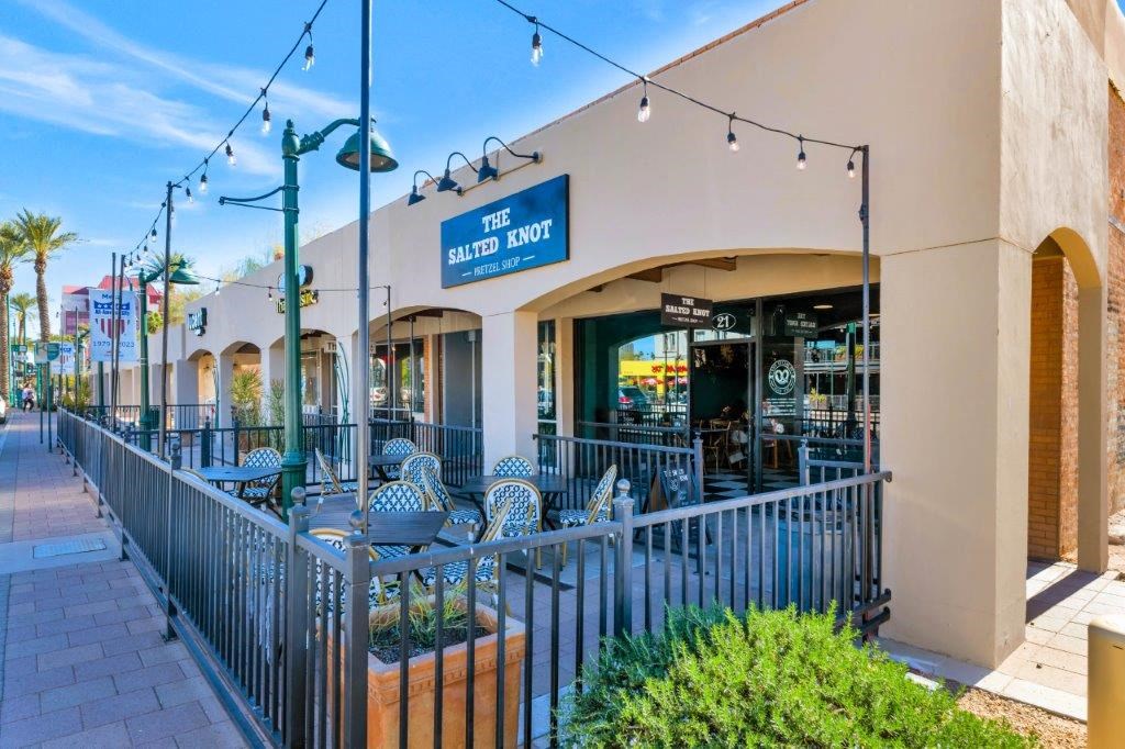 the outside of a restaurant with tables and chairs