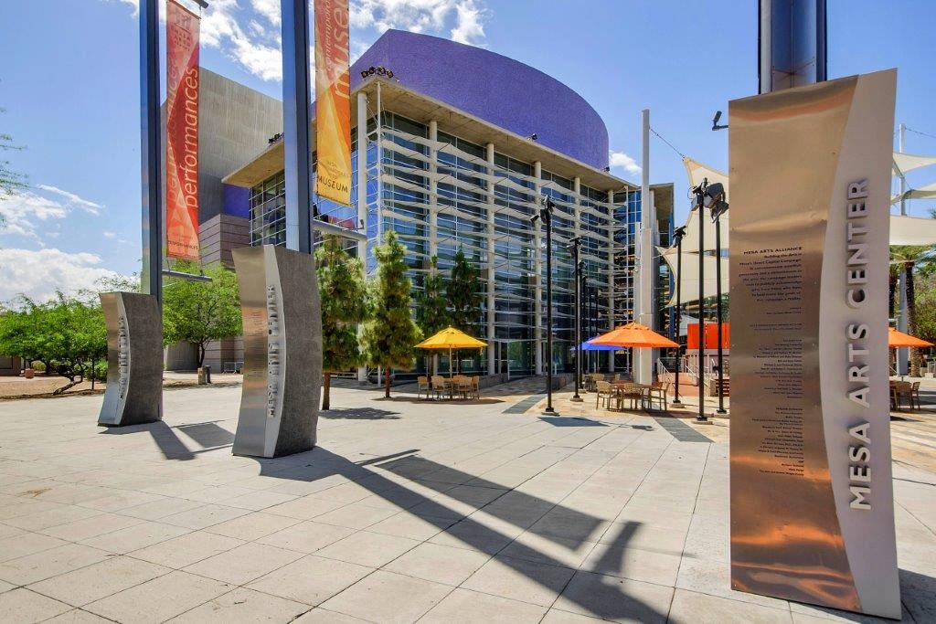 a city street with sculptures in front of a building