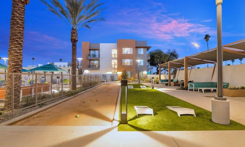a courtyard with benches and a pool with a building in the background