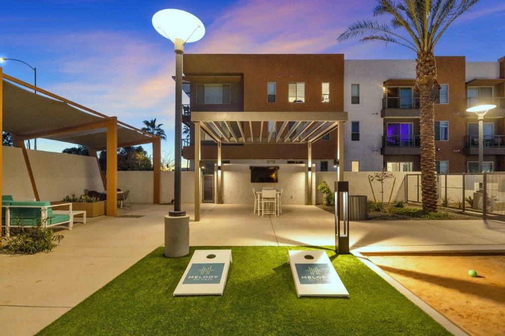 a courtyard with tables and chairs in front of a building