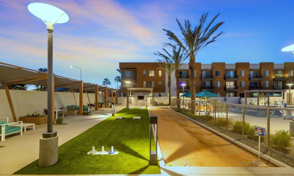 a beach area with chairs and grass and palm trees