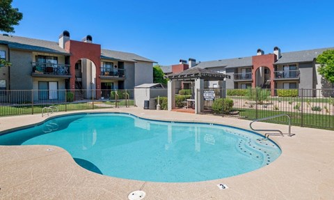 A swimming pool in front of apartment buildings at Reflections at Red Mountain Apartments, Mesa, Arizona