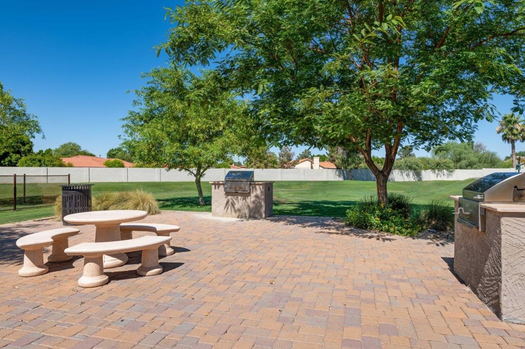 a picnic area with benches and trees in a park