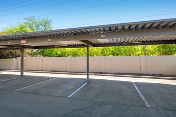 A parking lot with a concrete wall and a metal roof at Reflections at Red Mountain Apartments, Mesa