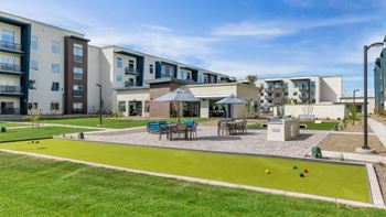 a grassy area with a bocce ball court in front of an apartment complex  at Glen 91, Arizona