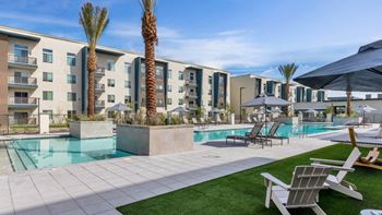 a swimming pool with chaise lounge chairs and umbrellas in front of an apartment building  at Glen 91, Arizona