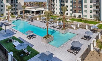 an aerial view of a resort style pool with chaise lounge chairs and umbrellas   at Glen 91, Glendale, Arizona
