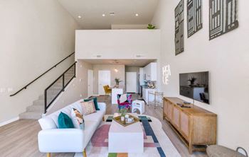 a living room with a white couch and a television