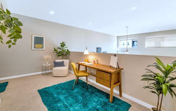a home office with a wooden desk and a green rug