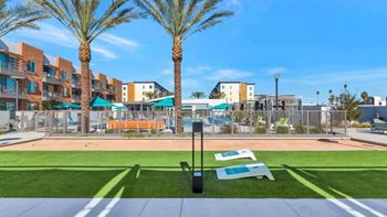 a dog park with benches and a tennis court in front of a pool and apartments