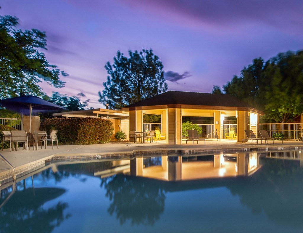 the pool and pavilion of a resort at night