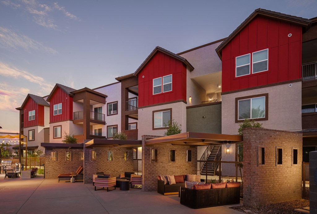 a group of townhomes with red and white facades at dusk at Weylyn Luxury Apartments, Laveen, AZ, 85339