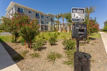A sign in front of a building instructs to leash and pick up after pets.