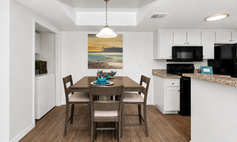 A dining room with a table set for four.
