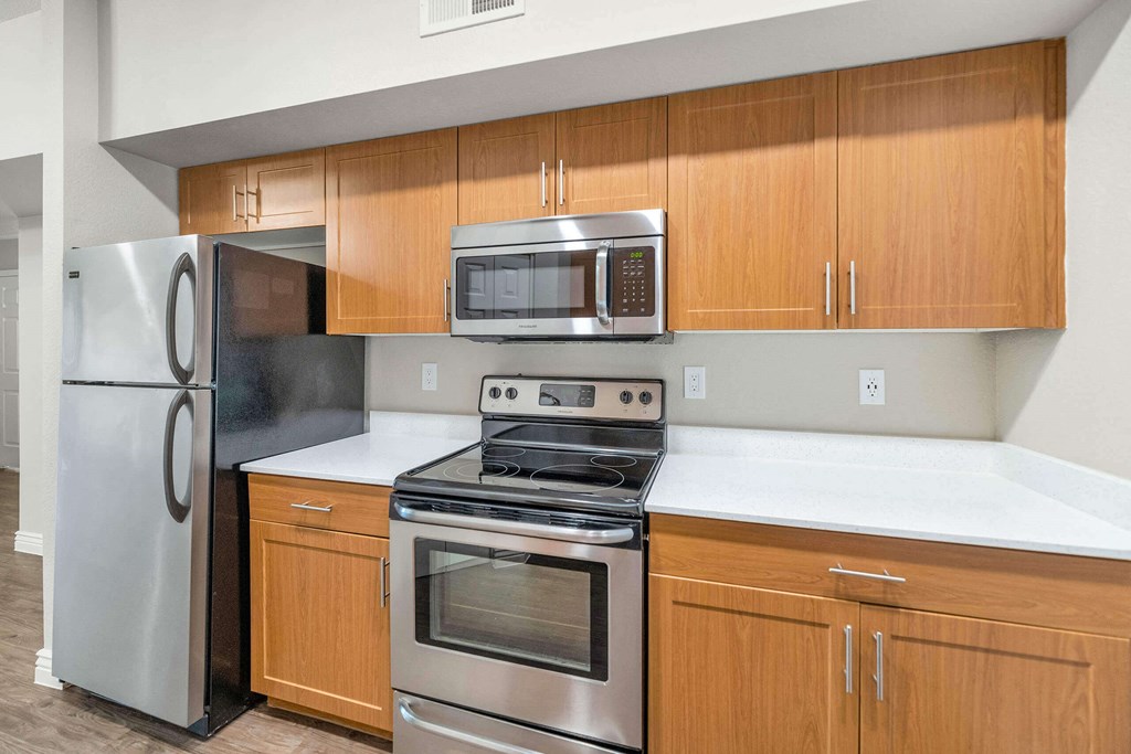 a kitchen with stainless steel appliances and wooden cabinets